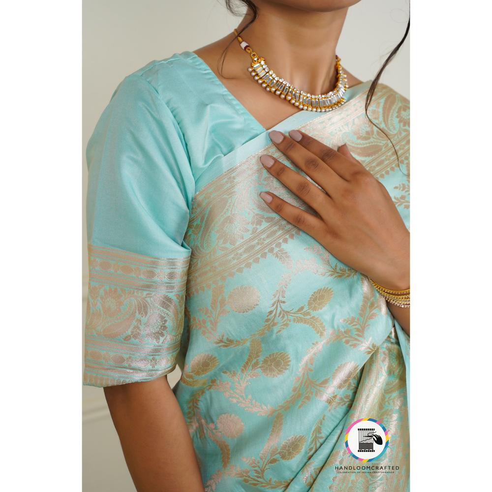 Sky blue Banarasi silk saree with intricate gold floral print, draped on a woman.