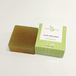 Handcrafted aloe vera and neem soap bar beside its green "She Made" box.