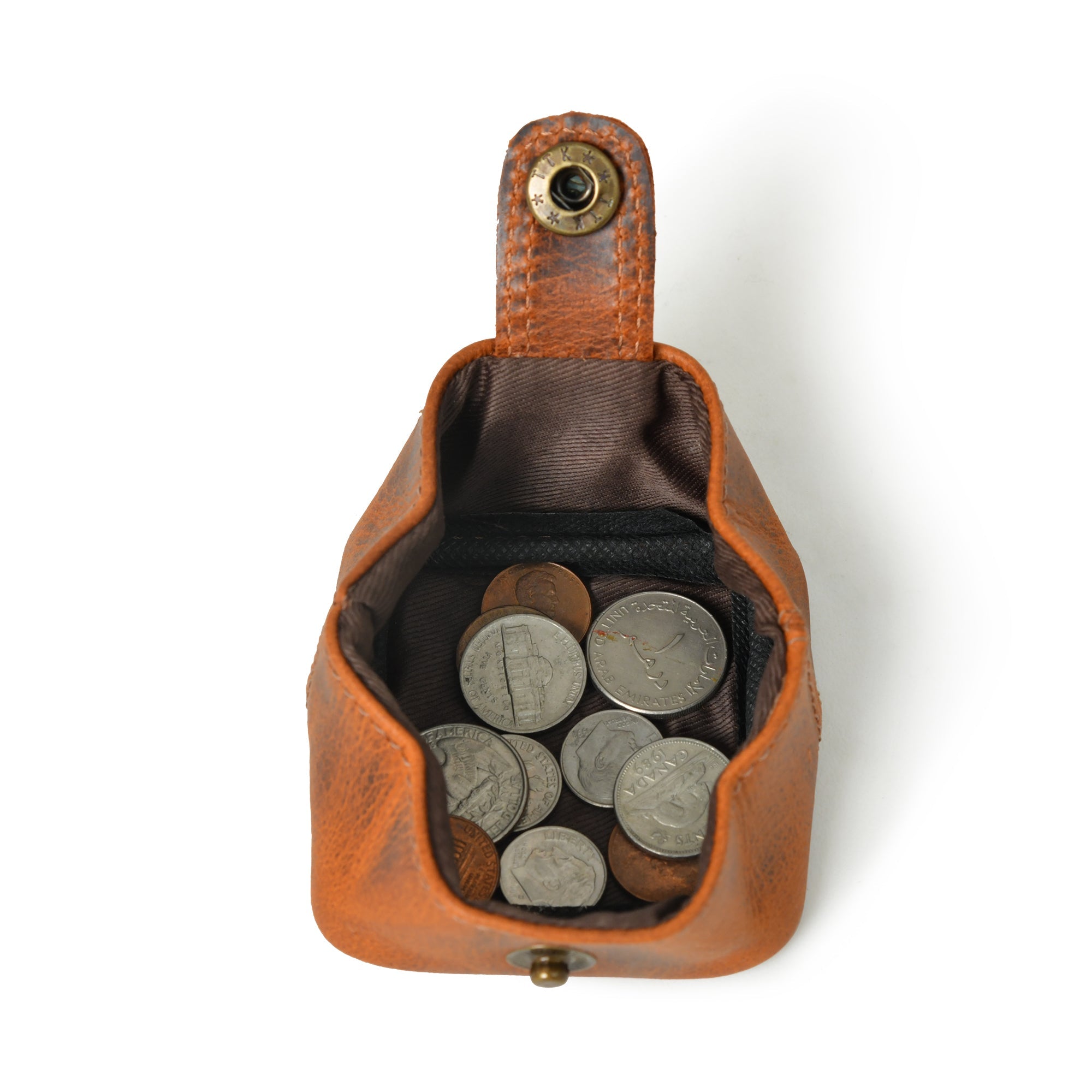 Open brown leather coin pouch with snap closure, filled with various coins.