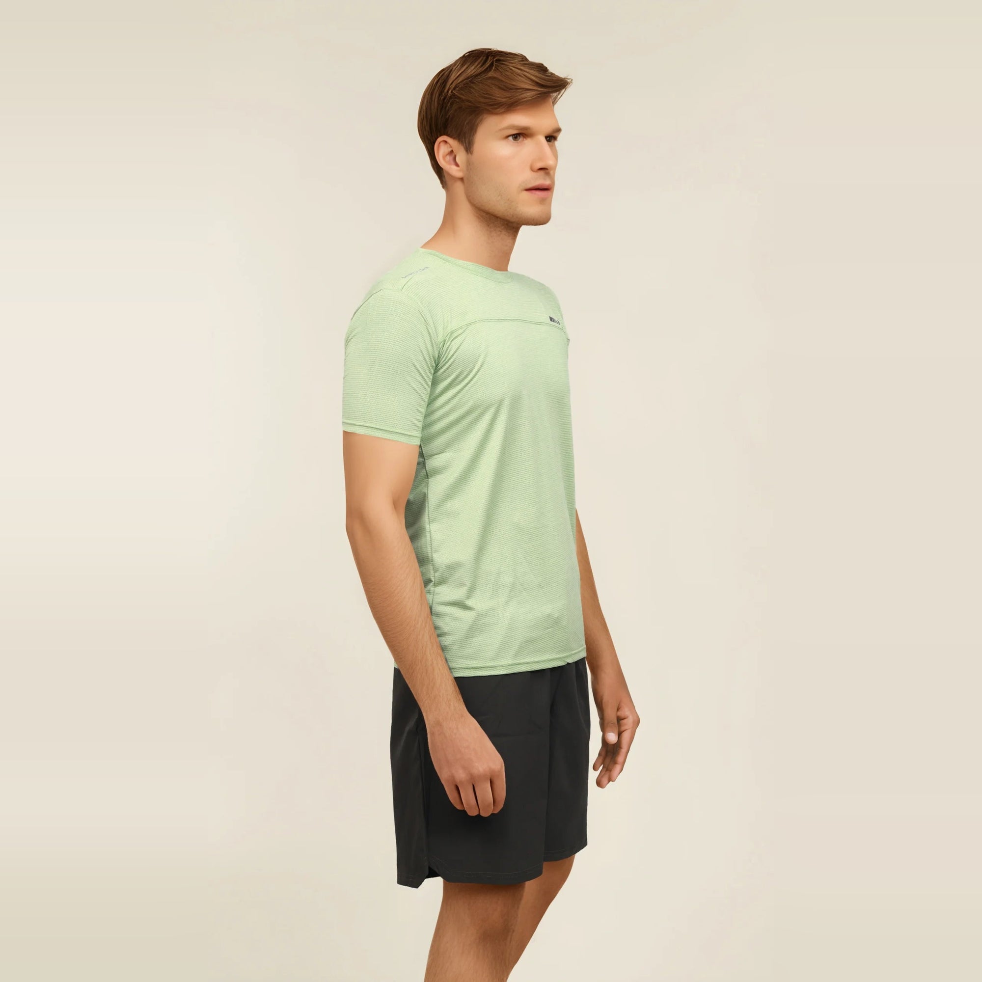 Man wearing a slim-fit, light green, short sleeve men's t-shirt.