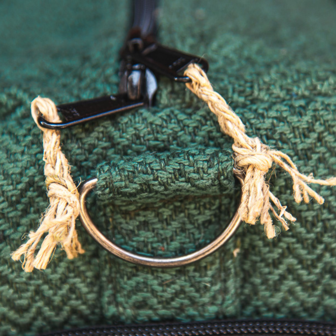 Close-up of the sturdy hemp fabric and rope zipper pulls on an eco-friendly green hemp duffle bag.