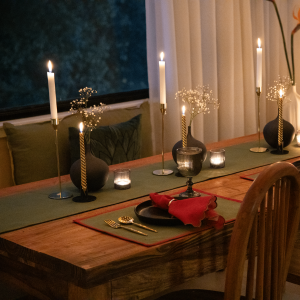 Enchant your dining experience with the Fairy Forest Placemats & Napkins Set. This image showcases the elegant green table runner and placemat with a matching napkin, adding a touch of whimsy to a candlelit table setting.