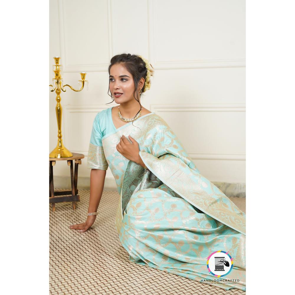 Woman elegantly wearing a sky blue Banarasi tissue silk saree with intricate gold print, perfect for special occasions.