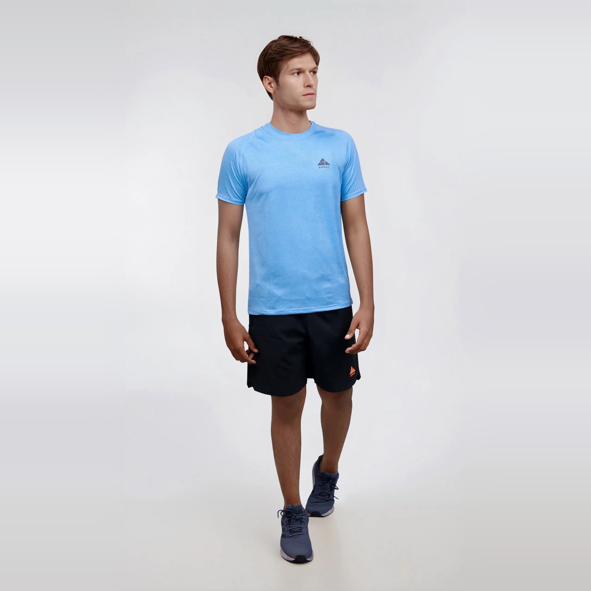 Man wearing a blue, short sleeve, dry-fit, crew neck T-shirt. Perfect for workouts or casual wear.