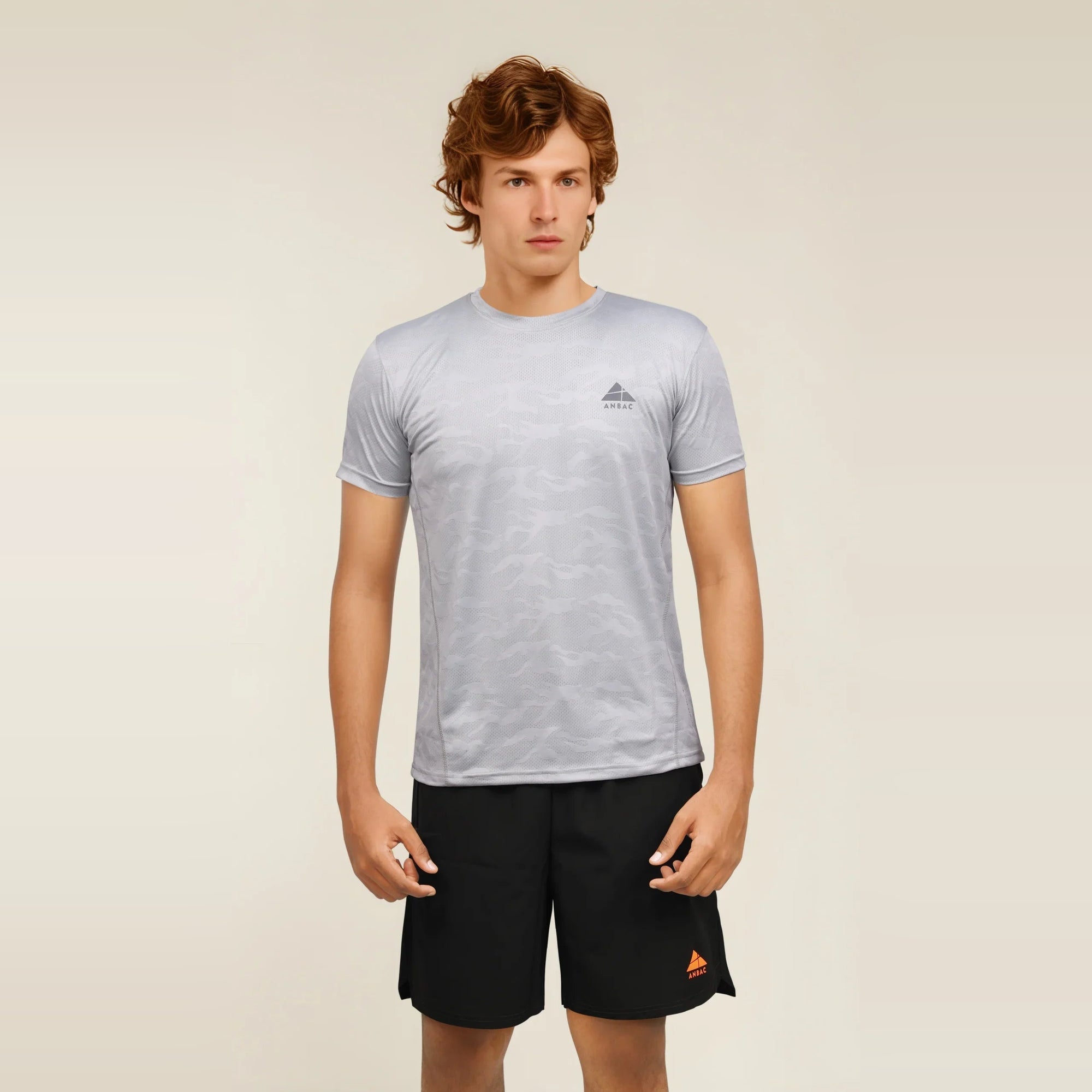 Man wearing a light gray, dry-fit, crew neck t-shirt, ideal for workouts and staying cool.