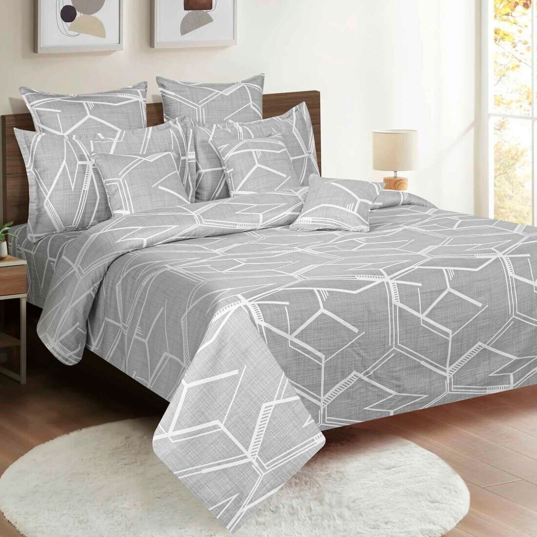 Gray bedsheets with a white hexagonal geometric pattern on a king-size bed.