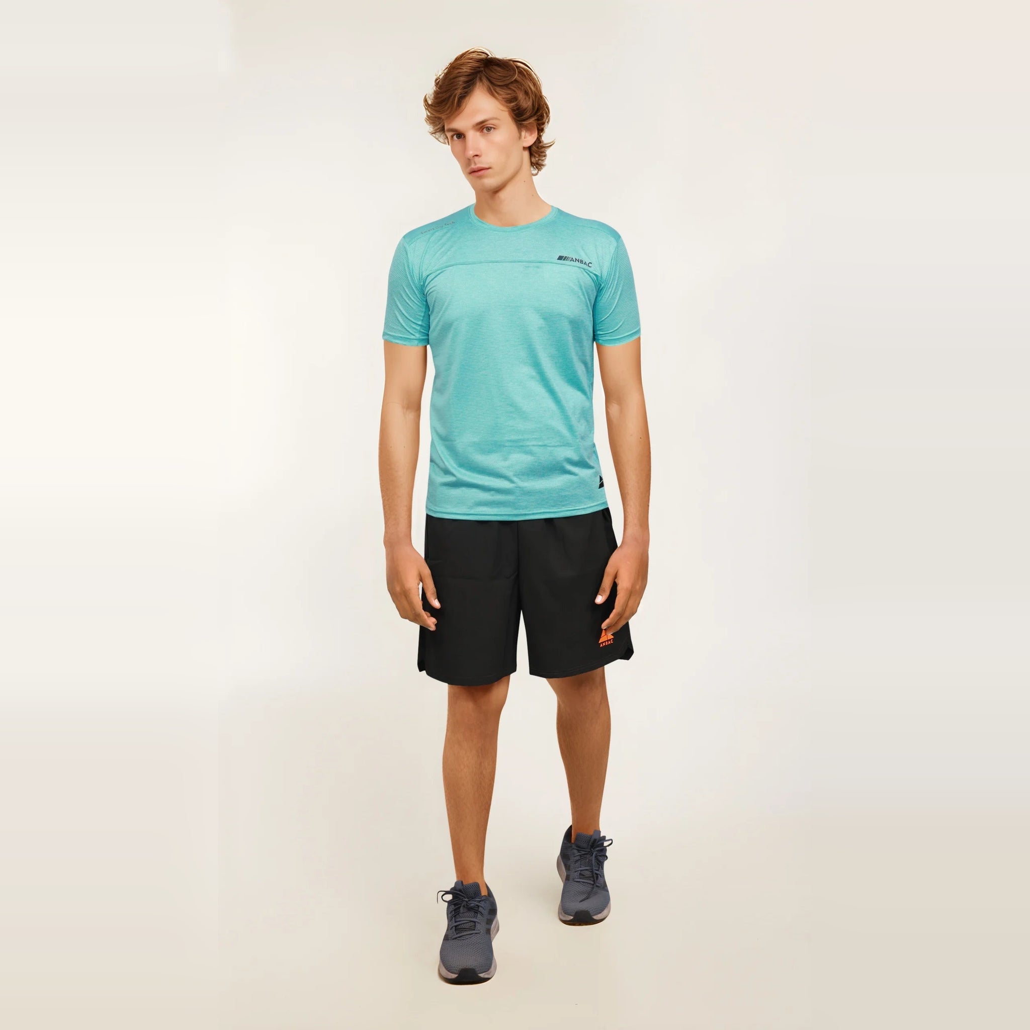 A man models a light blue Men's Casual Slim Fit Short Sleeve T-Shirt paired with athletic shorts and sneakers.