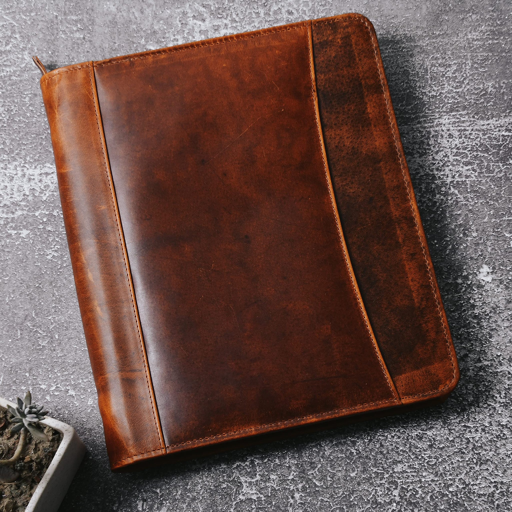 Stylish brown leather padfolio, perfect for professionals. Features card and pen holders for organization.