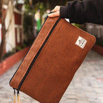 Hand holding a rustic brown Himalayan Natural Hemp Laptop Sleeve, showcasing its eco-friendly and durable design.