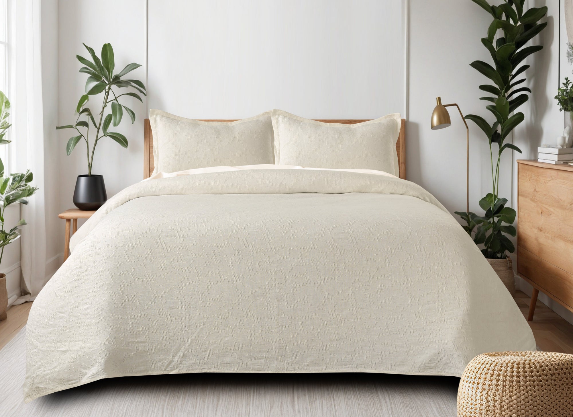 Milky white waffle-weave cotton bedspread with subtle texture on a made bed with two matching pillow shams.