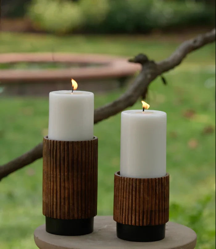 Set of 3 unscented white pillar candles in varying sizes, nestled in rustic brown wooden holders.