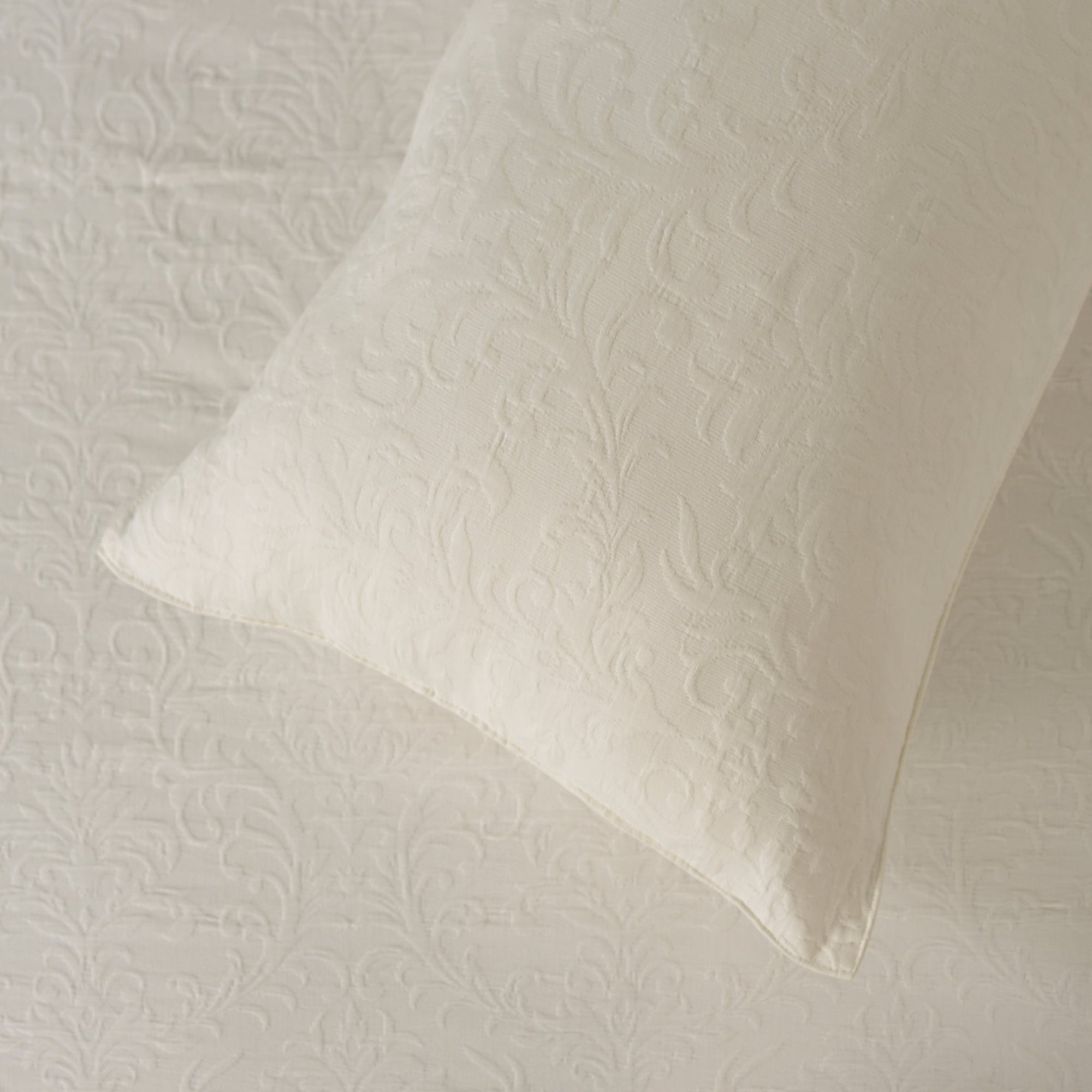 Ivory white matelassÃƒÂ© cotton bedcover and sham with a subtle floral design.