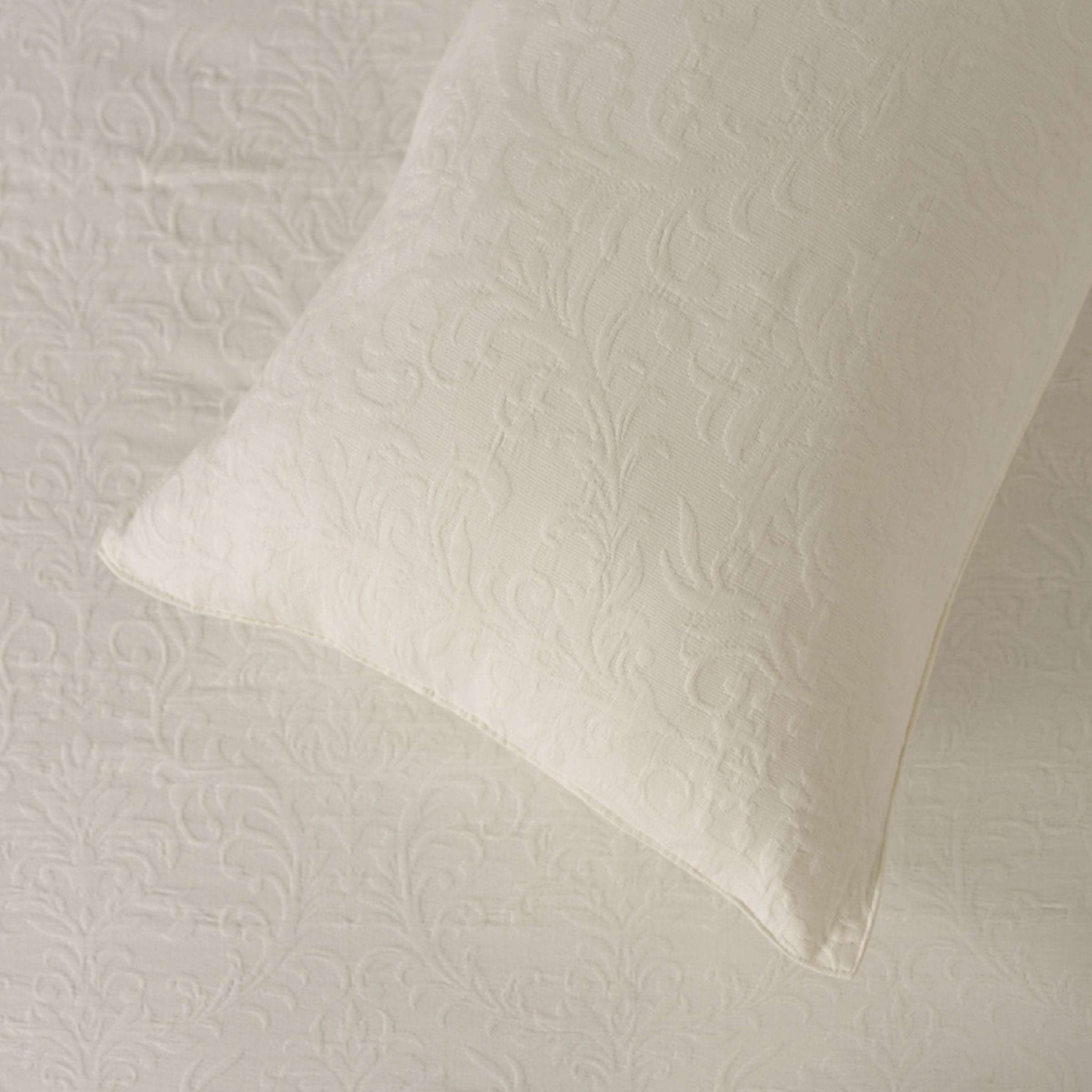 Ivory white matelassÃƒÆ’Ã‚Â© cotton bedcover and sham with a subtle floral design.