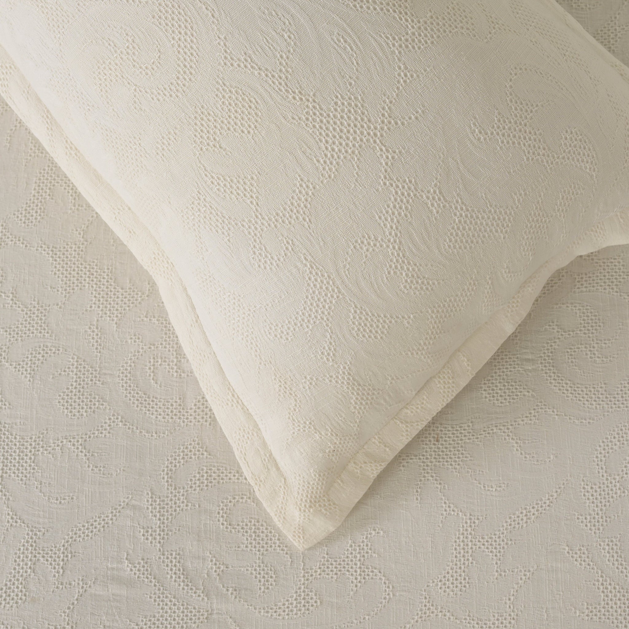 Milky white waffle-textured cotton bedspread and sham set with a subtle woven gardenia pattern.