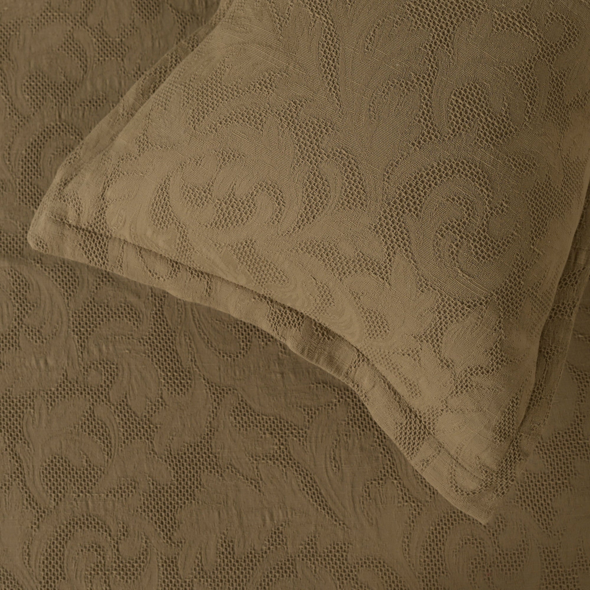 Sage green waffle-textured cotton bed sheet with a floral design and matching pillow sham.