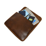 Stylish brown leather portfolio open and filled with a laptop, notebook, wallet, and pens.