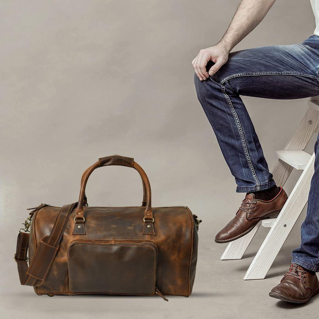 A stylish brown leather duffle bag with a front pocket and a detachable shoulder strap. Perfect weekend or travel bag for men.