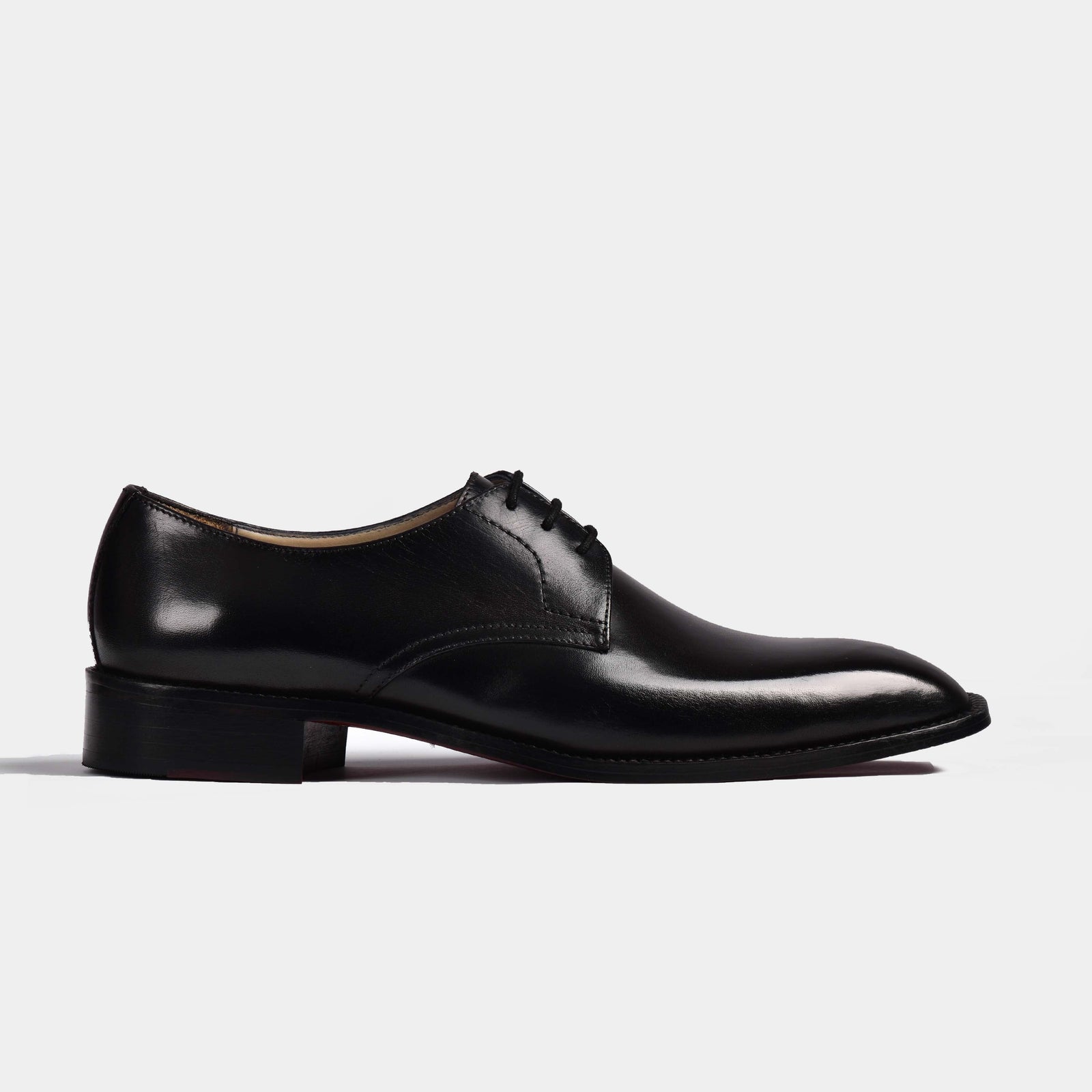 A pair of Reuben Lincoln Leather Laceups in black, showcasing their sleek profile and polished leather finish.