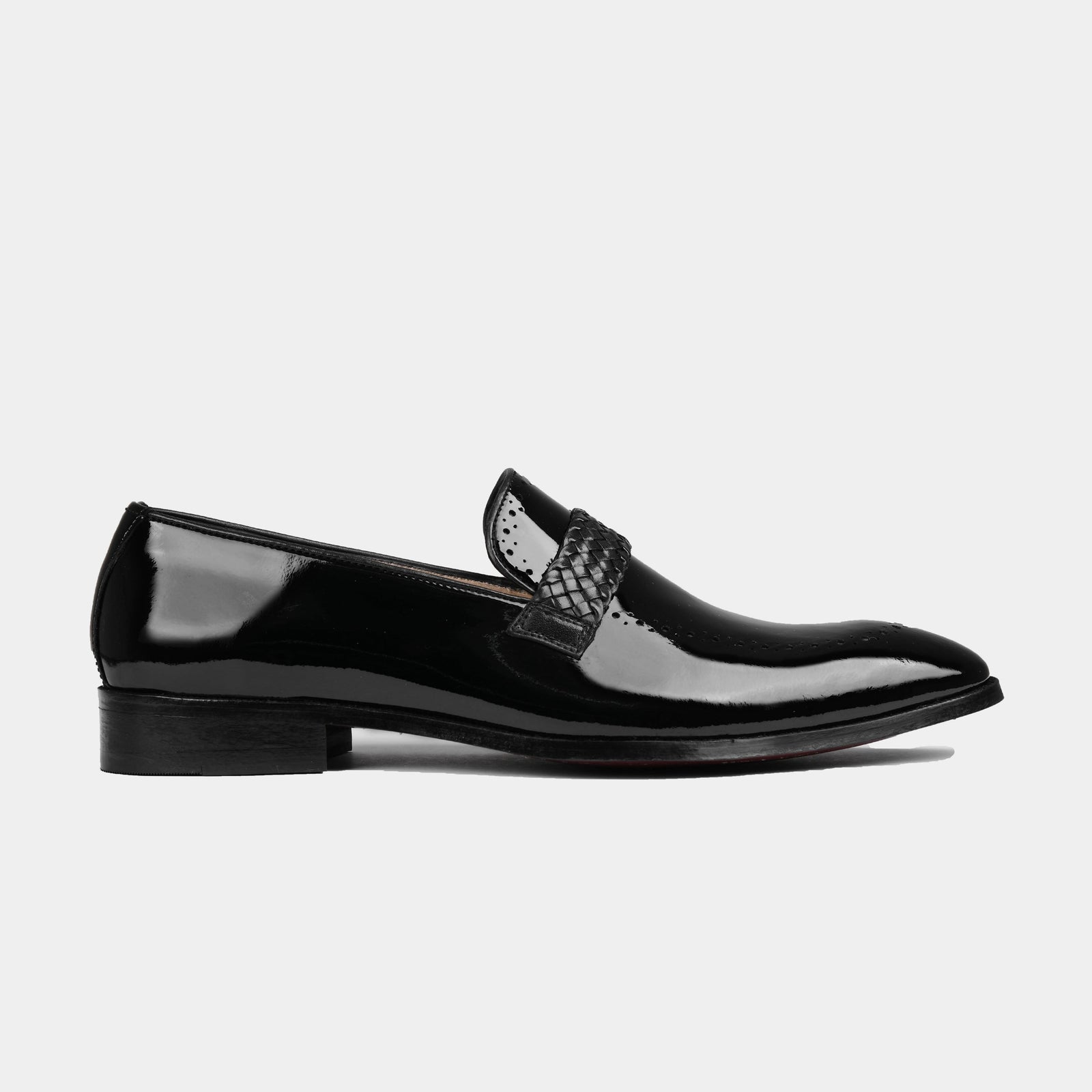 A side view of the Atilio Patent Leather Loafers in black, featuring a woven leather strap and subtle broguing.