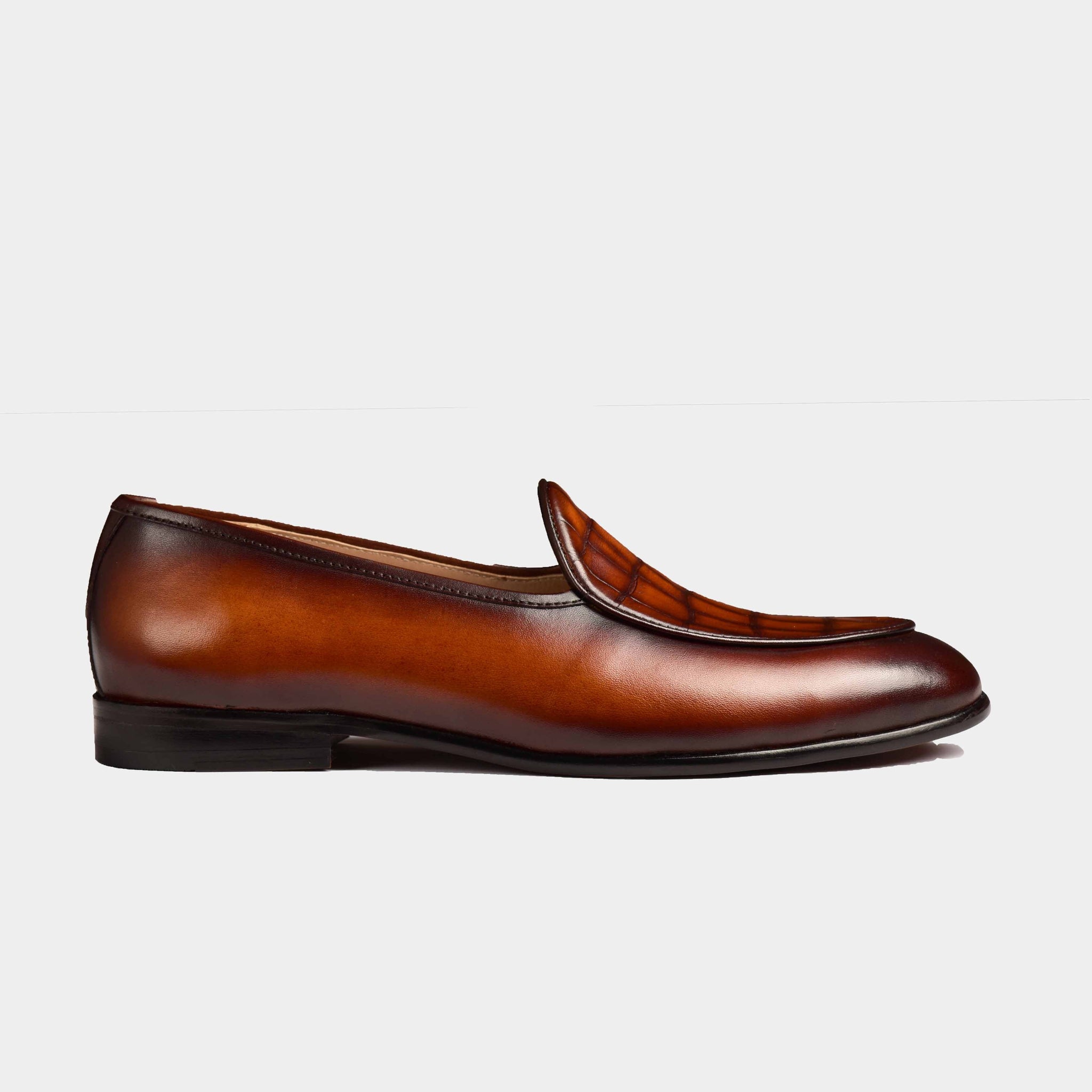 A side view of the Arno Loafers in brown patina leather with a textured toe cap.