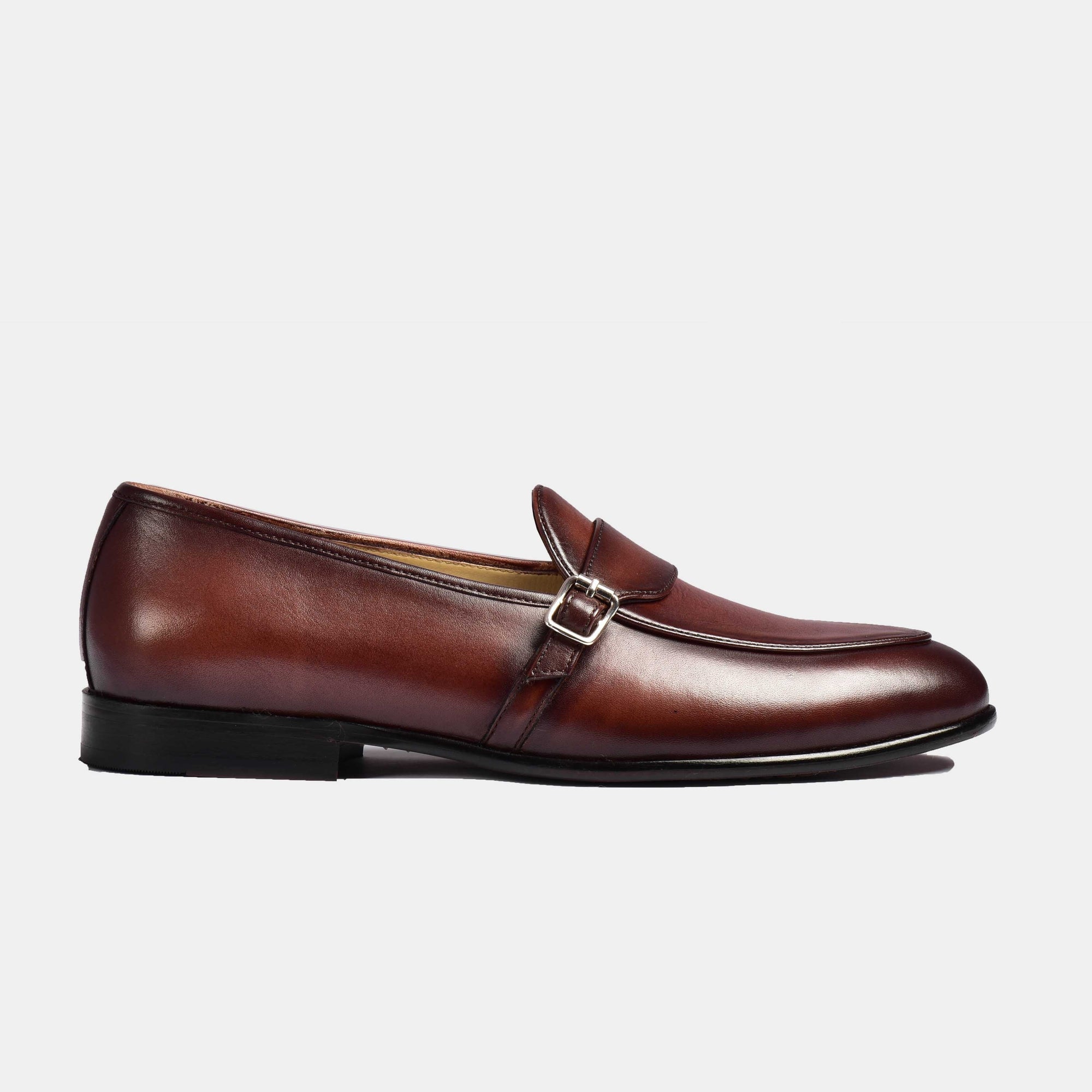 Pair of brown patina Arno Loafers with a sleek buckle strap across the front.