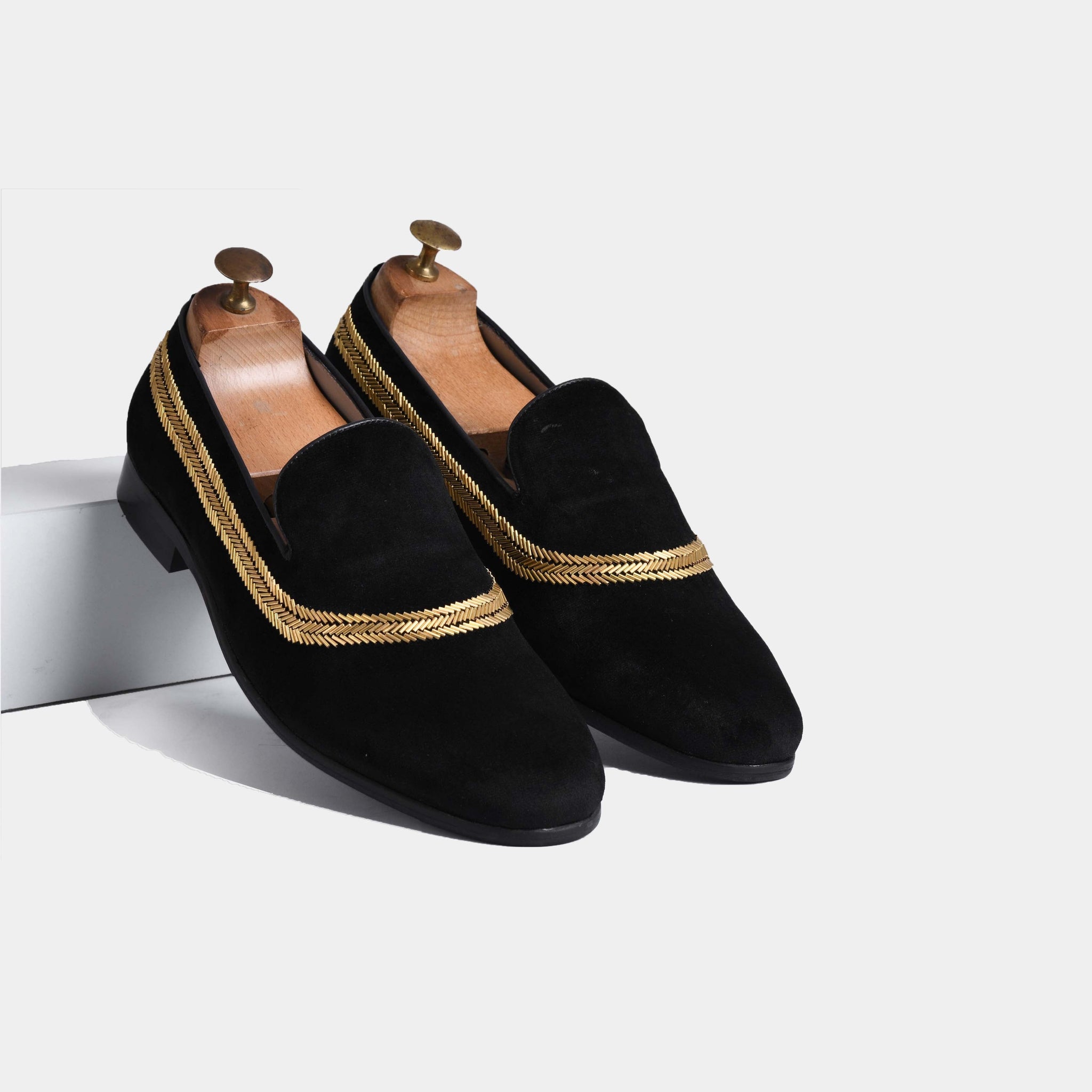 Pair of Alvaro Black Embroidered Leather Slip-Ons with gold braided trim, shown on shoe trees.