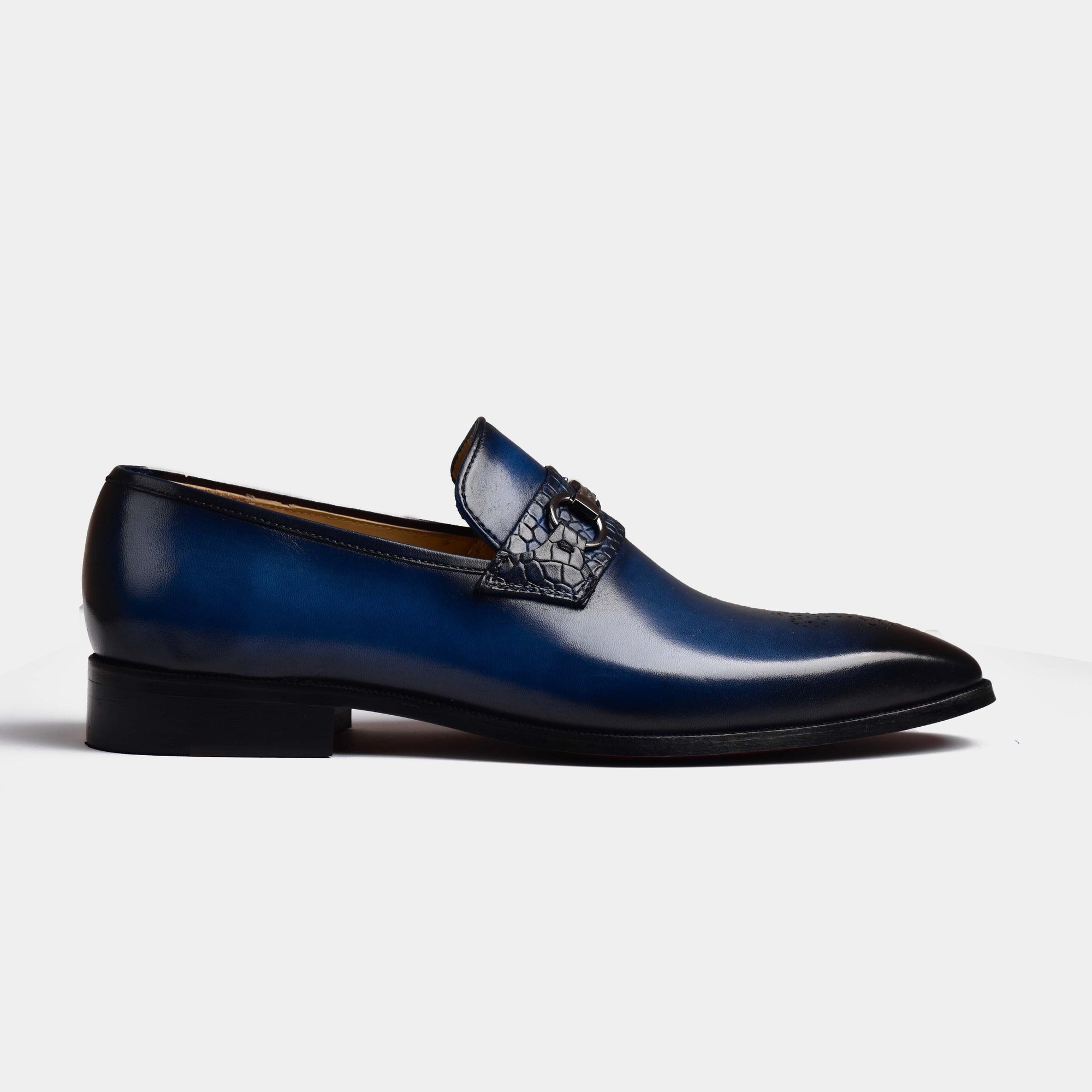 A single Mauricia Blue Loafer, crafted from blue leather with a textured strap, sits on a white background.