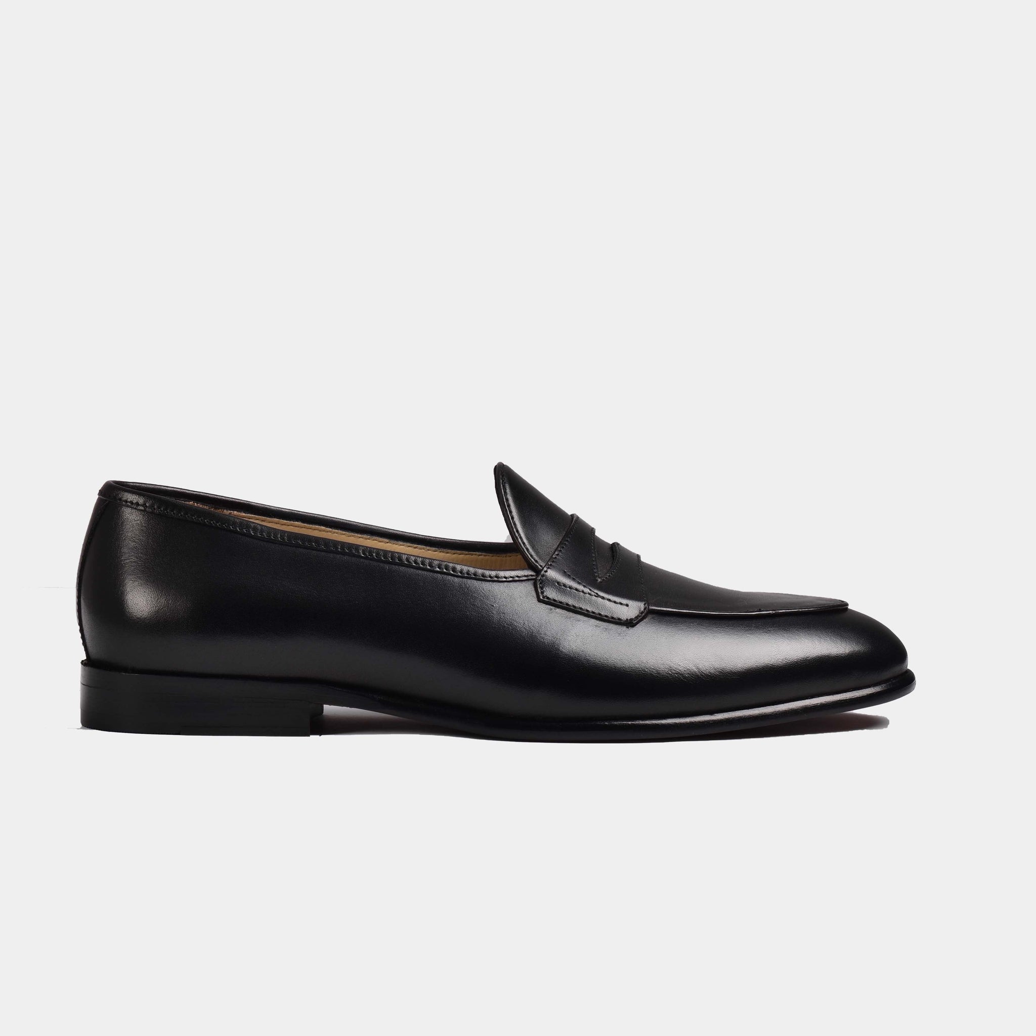 Black patina Arno loafers with a classic grand penny detail, showcasing a sleek side profile.