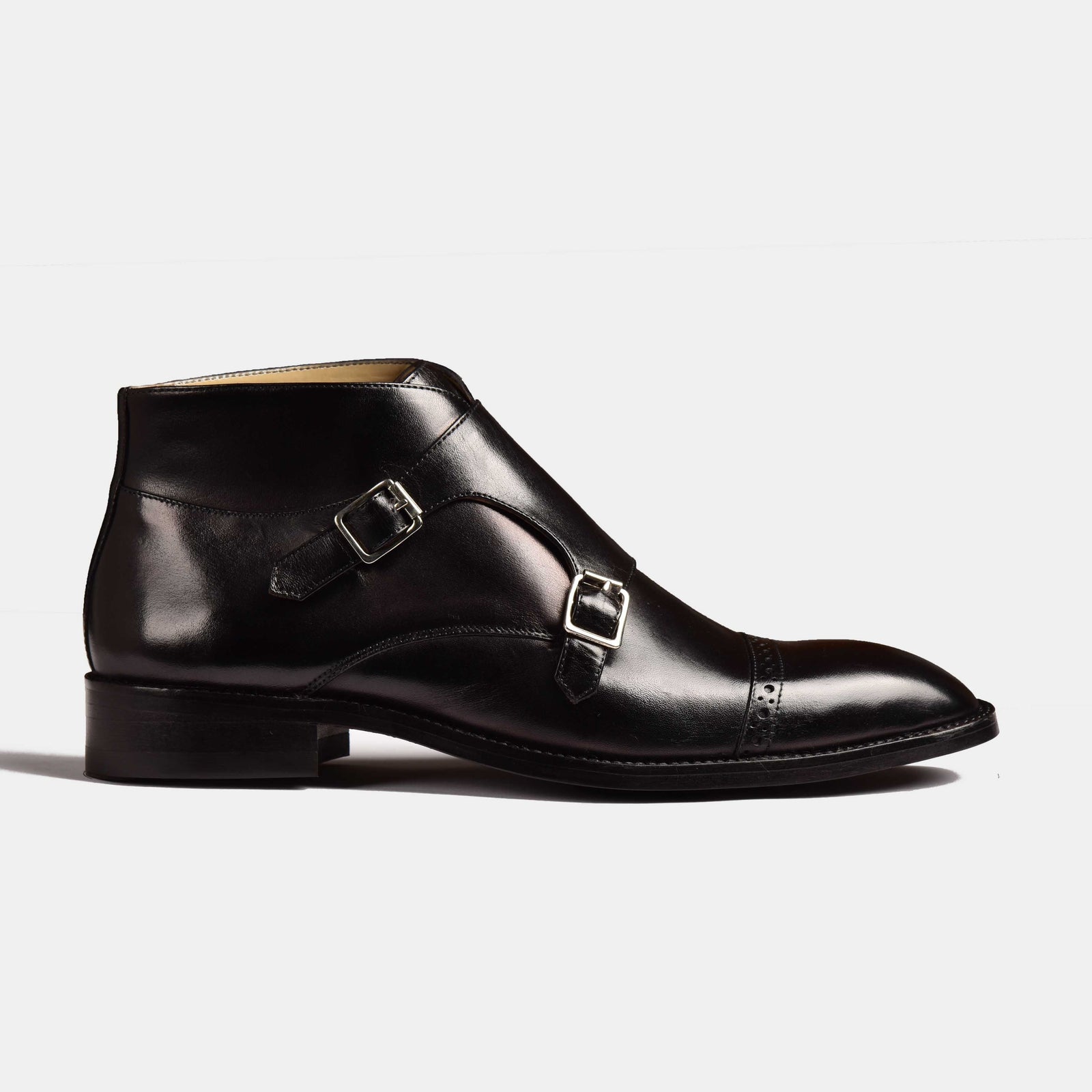 Side view of a black leather Alfred Double Monk Boot with double buckle closure and brogue detailing.