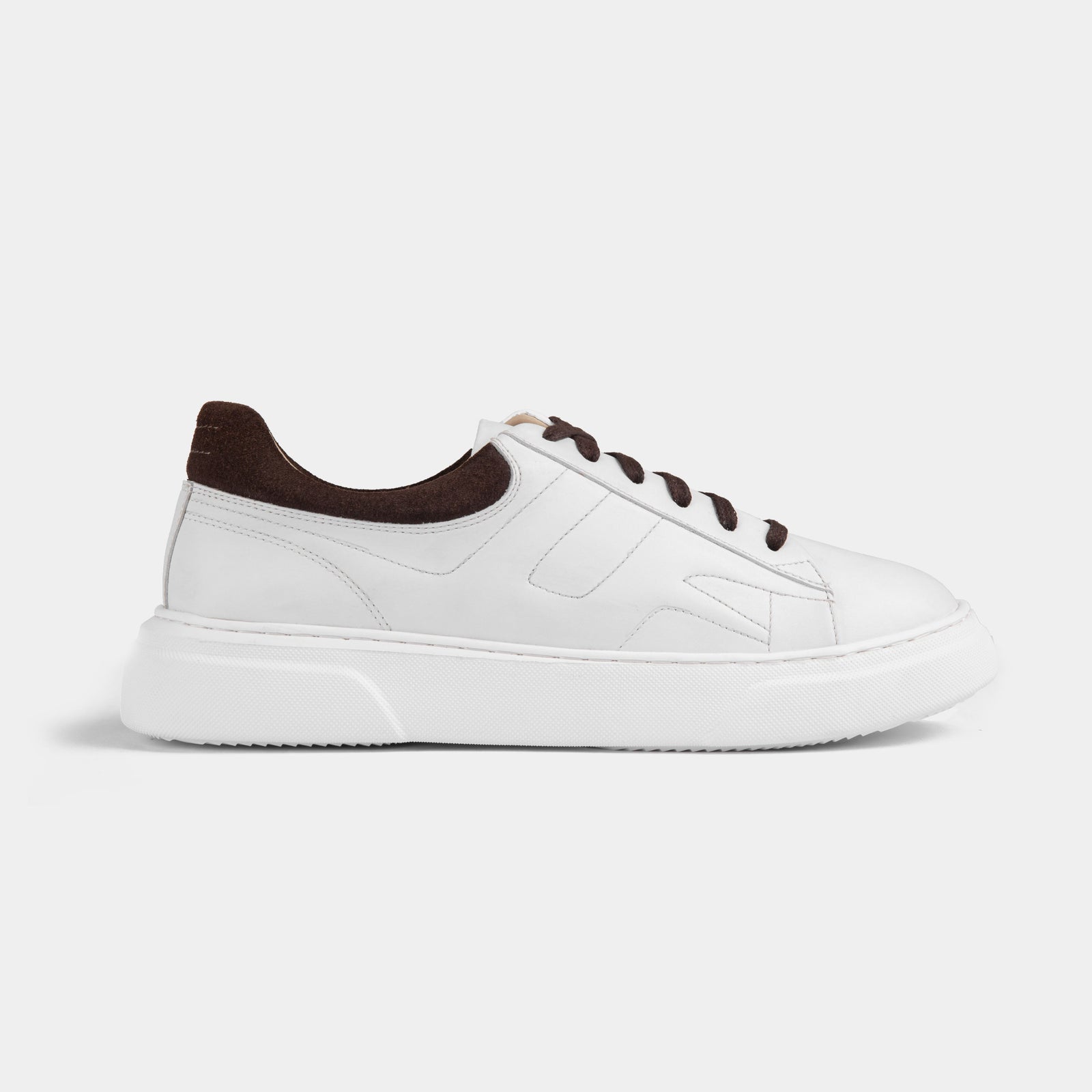 Pair of white leather men's sneakers with brown suede accents and white laces on a white background.