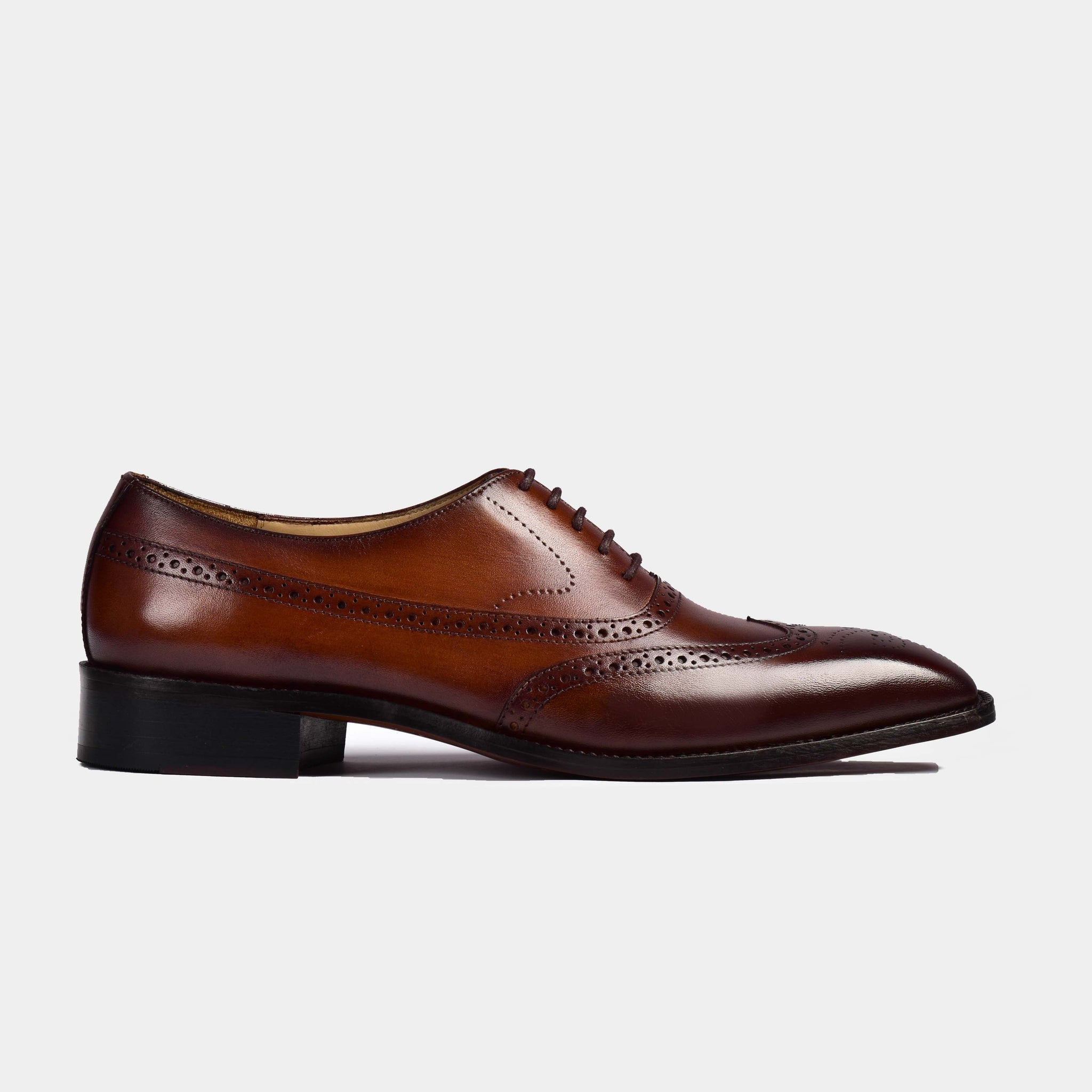 Side view of a single brown Melvin Litt Leather Laceup shoe with brogue detailing and a black heel.