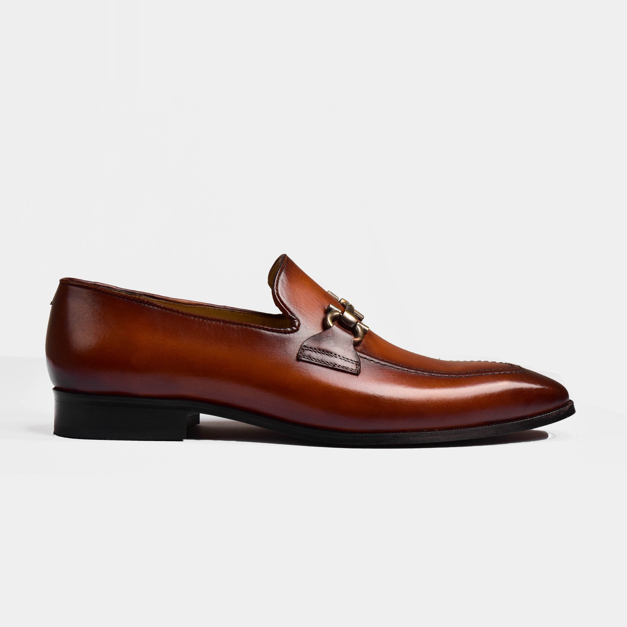 Side view of Dario Tan Leather Loafers showcasing the polished tan leather, gold buckle accent, and sleek silhouette.