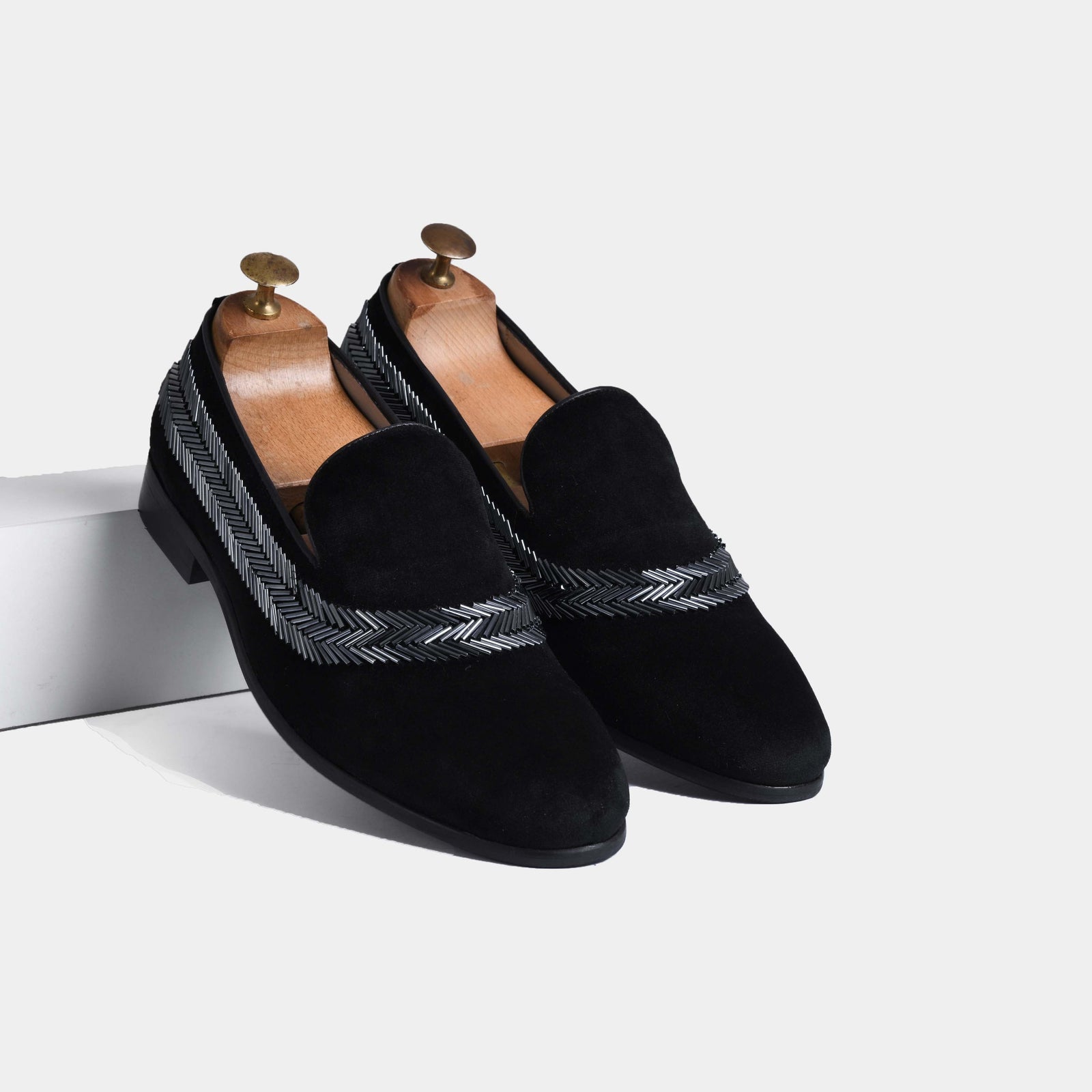 Pair of black velvet Alvaro men's slip-on loafers with silver embroidered chevron detailing and leather footbeds.