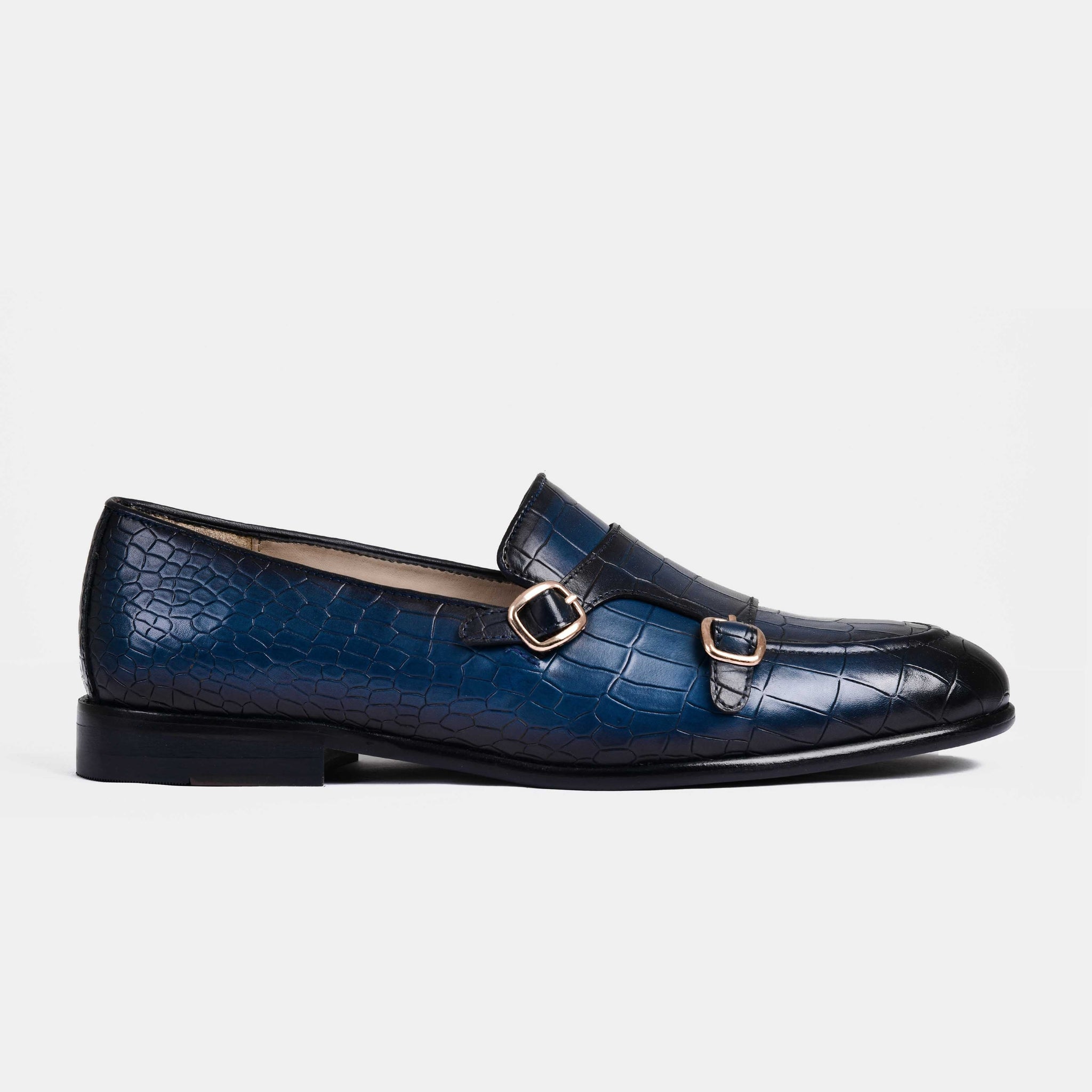 A pair of Valeria Croc Blue Leather Monk Straps shoes with double buckles on white background.