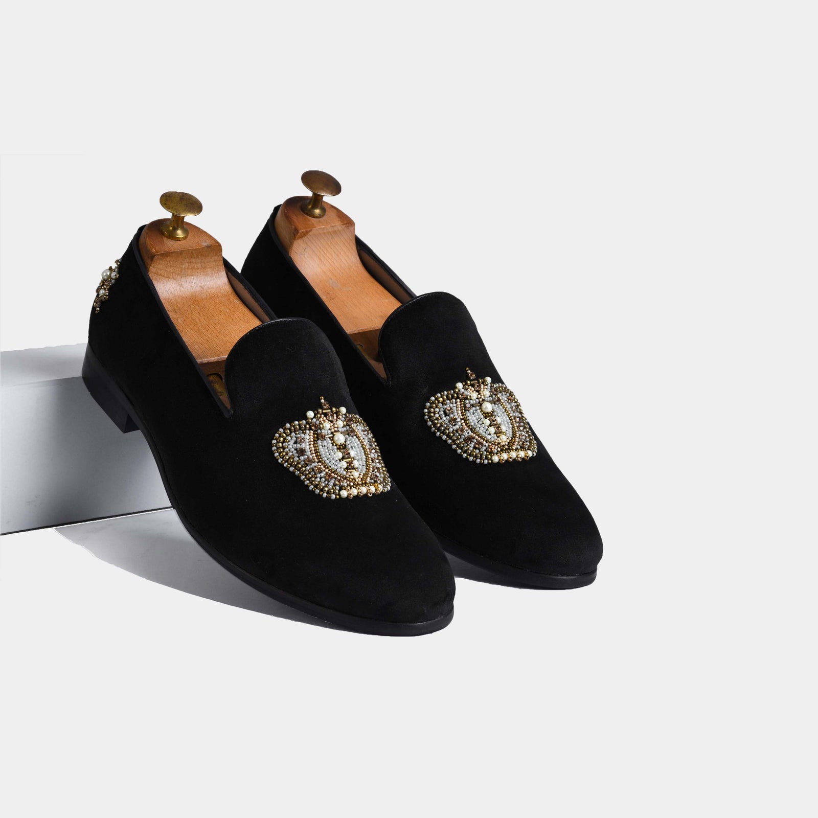 Pair of Elizar Black Embroidered Leather Slip-Ons with intricate beading and pearl detail on black suede.