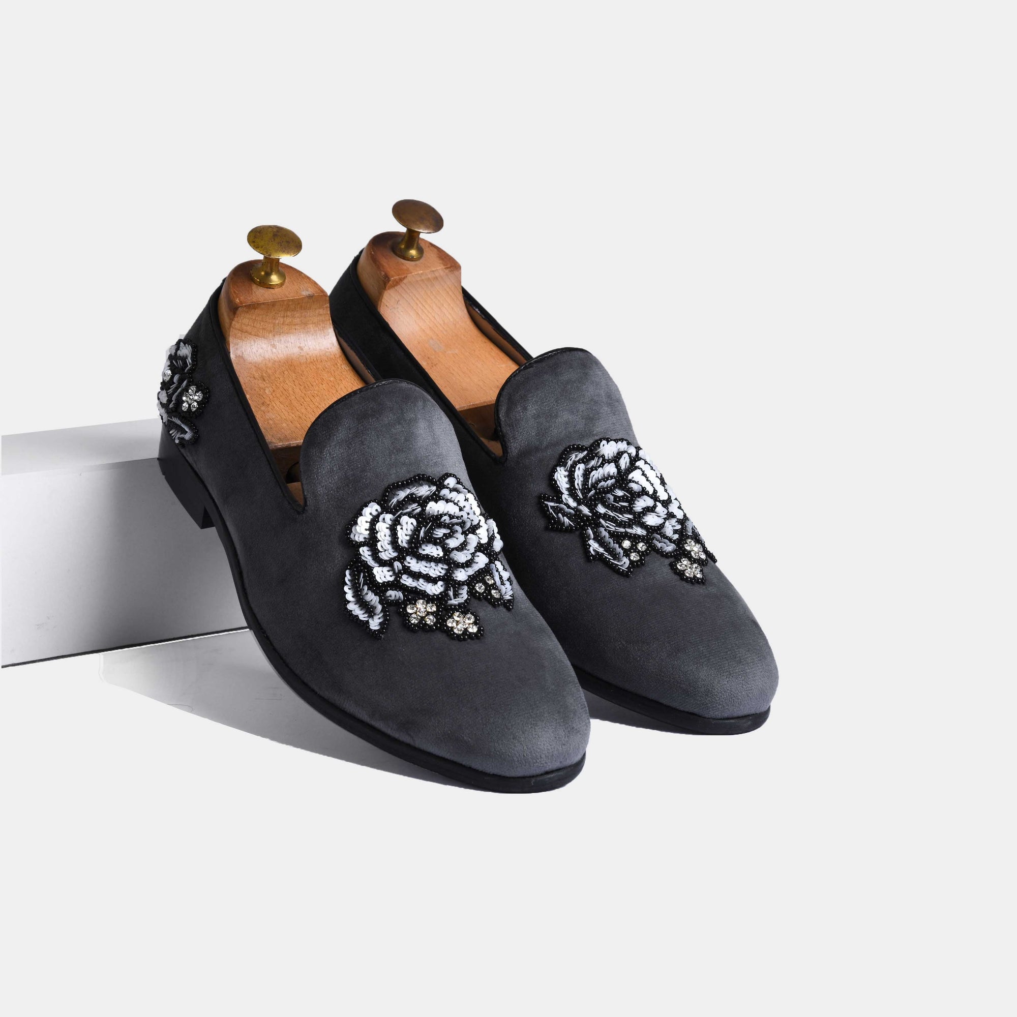 Pair of Cesar Grey Embroidered Leather Slip-Ons with a floral embroidery in black, white, and grey beads on the vamp.