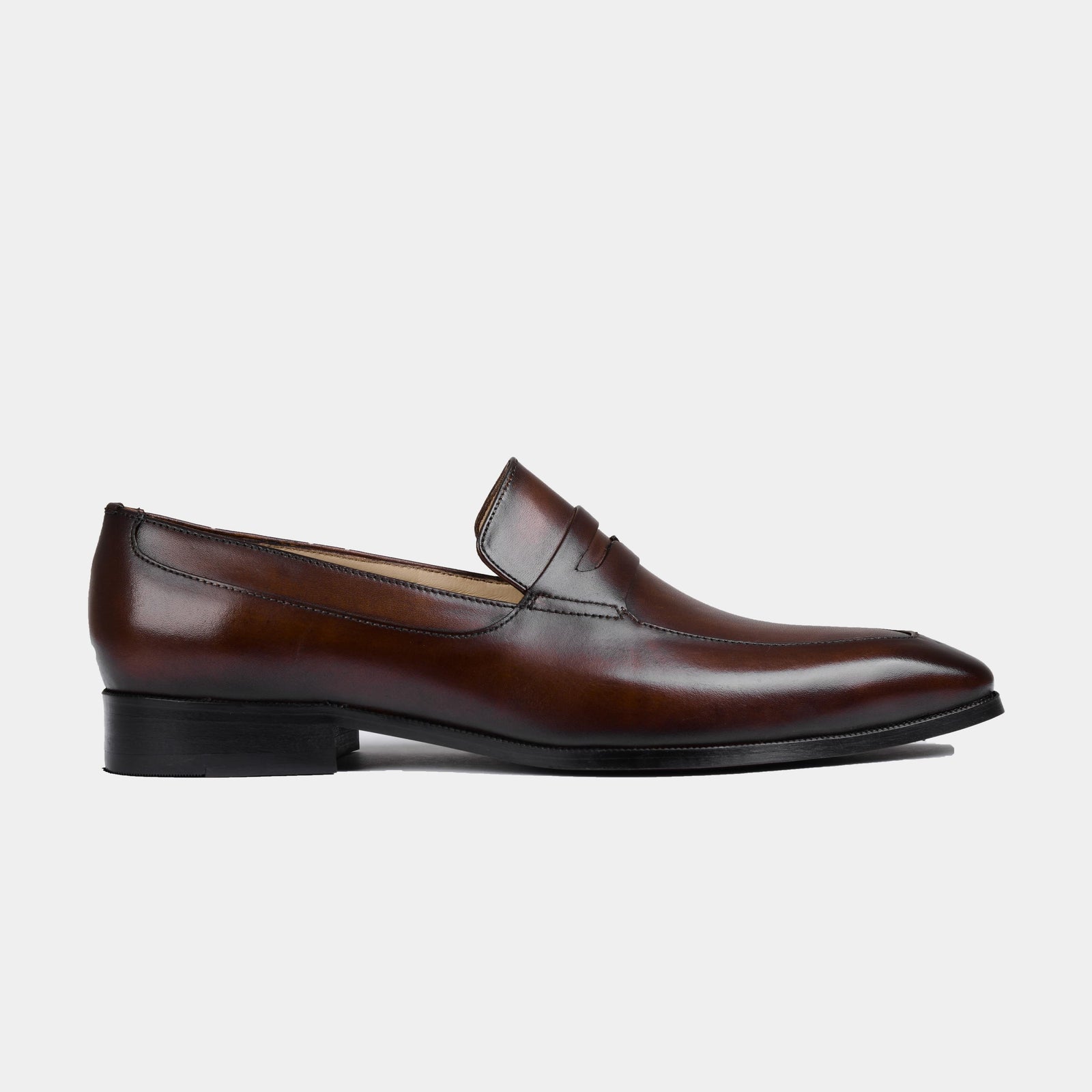 Side view of Andres Brown Loafers, showcasing the sleek silhouette and polished brown leather.