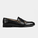 A pair of Valeria Croc Black Leather Monk Straps with gold buckles on a white background.