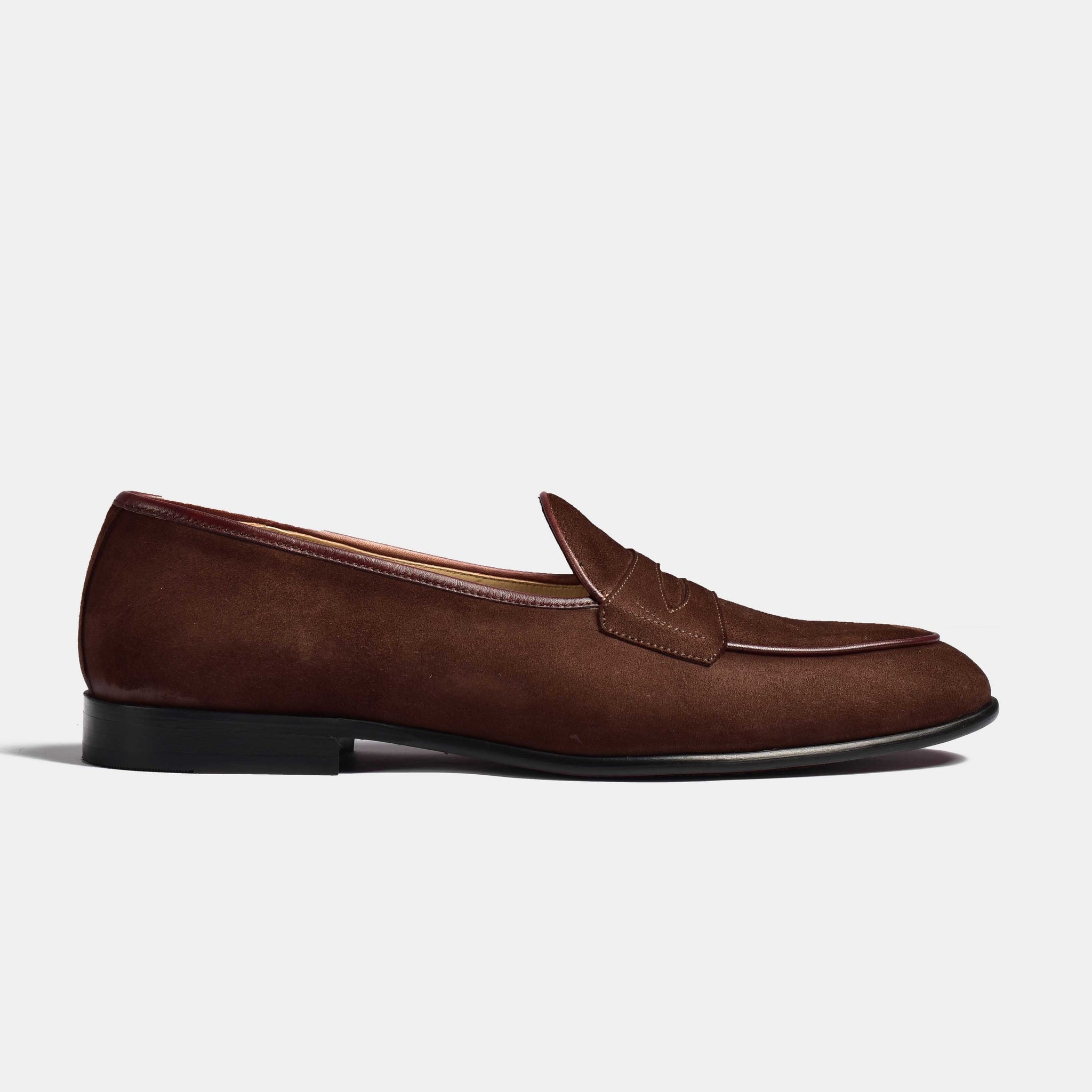 A side view of the Arno Loafer in brown suede. The loafer features a classic penny strap detail.