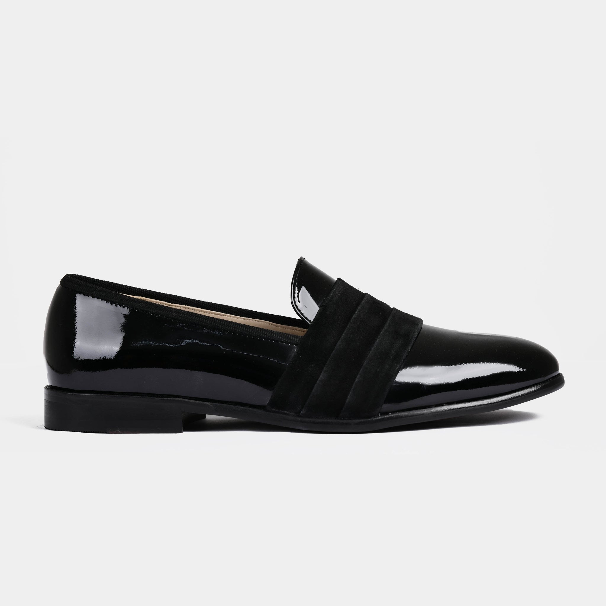 Pair of Delmar Black Patent Loafers with a suede strap across the top.