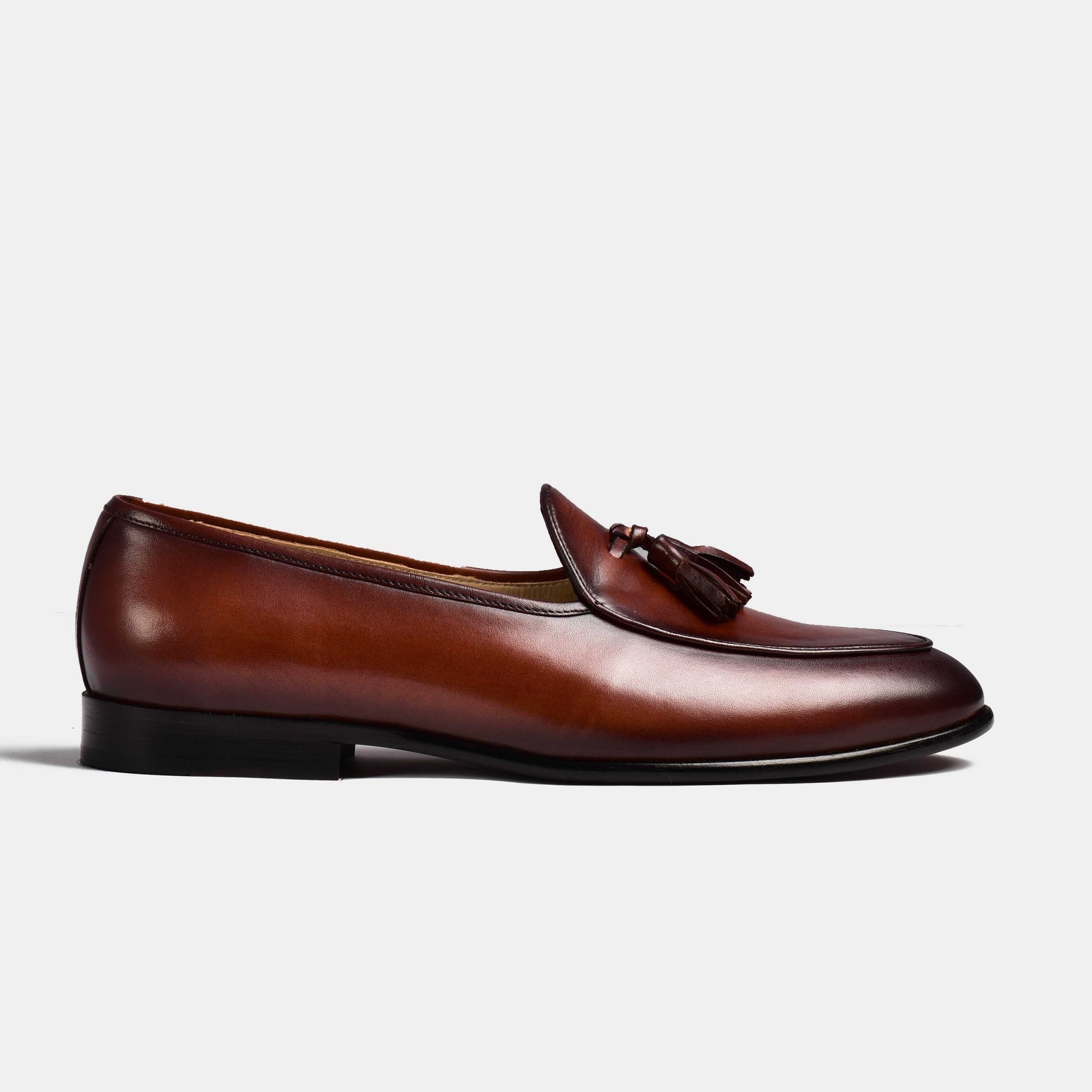 A pair of brown patina Arno Loafers with classic tassels.