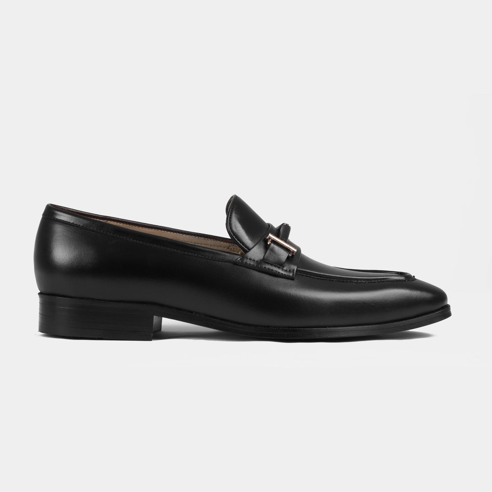 Adelmo black leather loafers with a subtle gold buckle, viewed from the side.