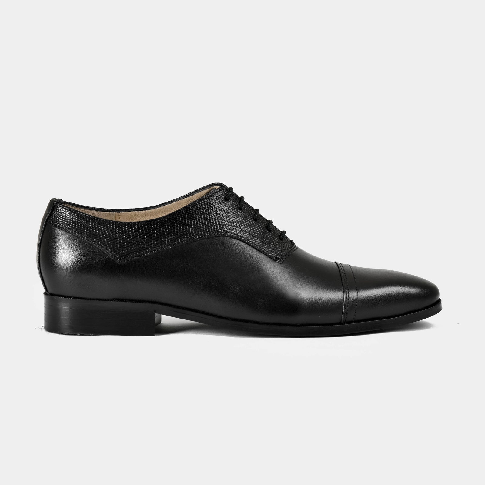 Elvio black leather lace-up dress shoe with textured paneling. Side view.