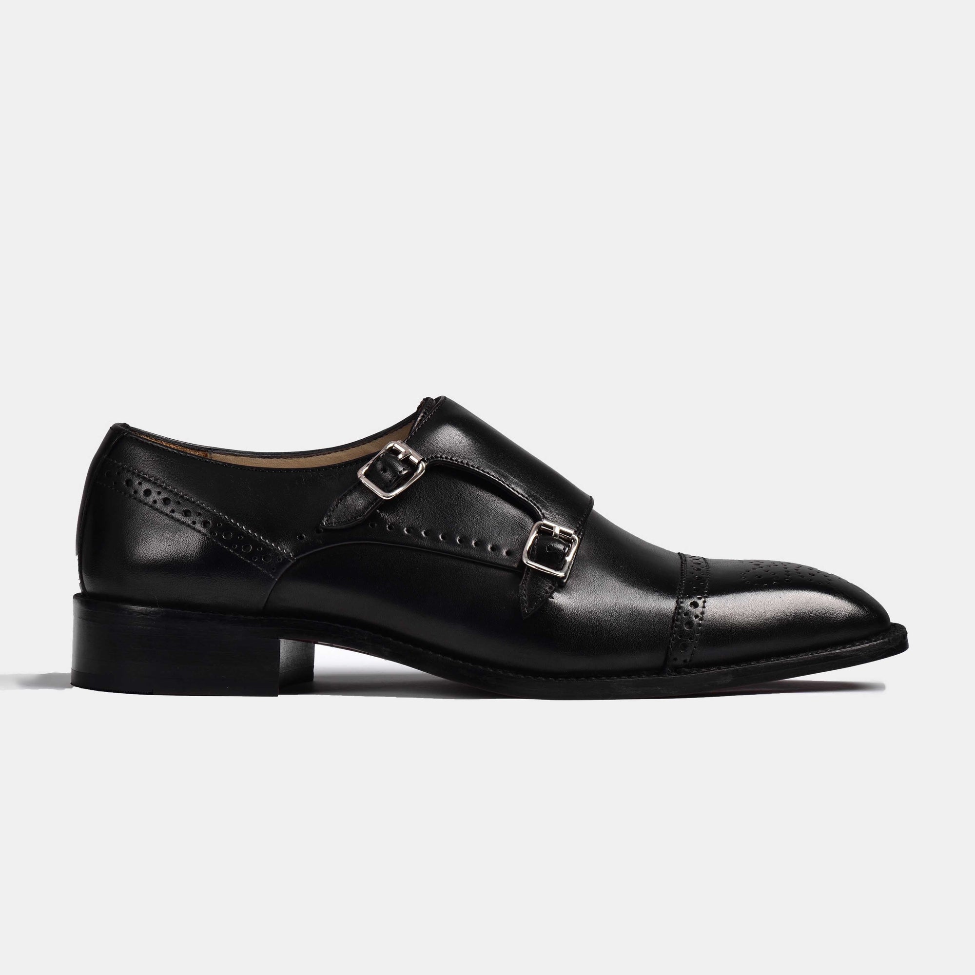 A side view of the Aldrich Black Monk Strap shoes, showcasing the sleek black leather and double monk strap design.