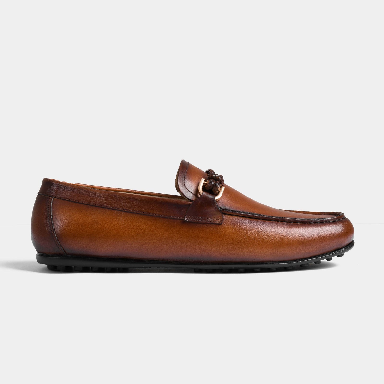 Tan leather driving loafers, featuring a braided strap with metal detailing.