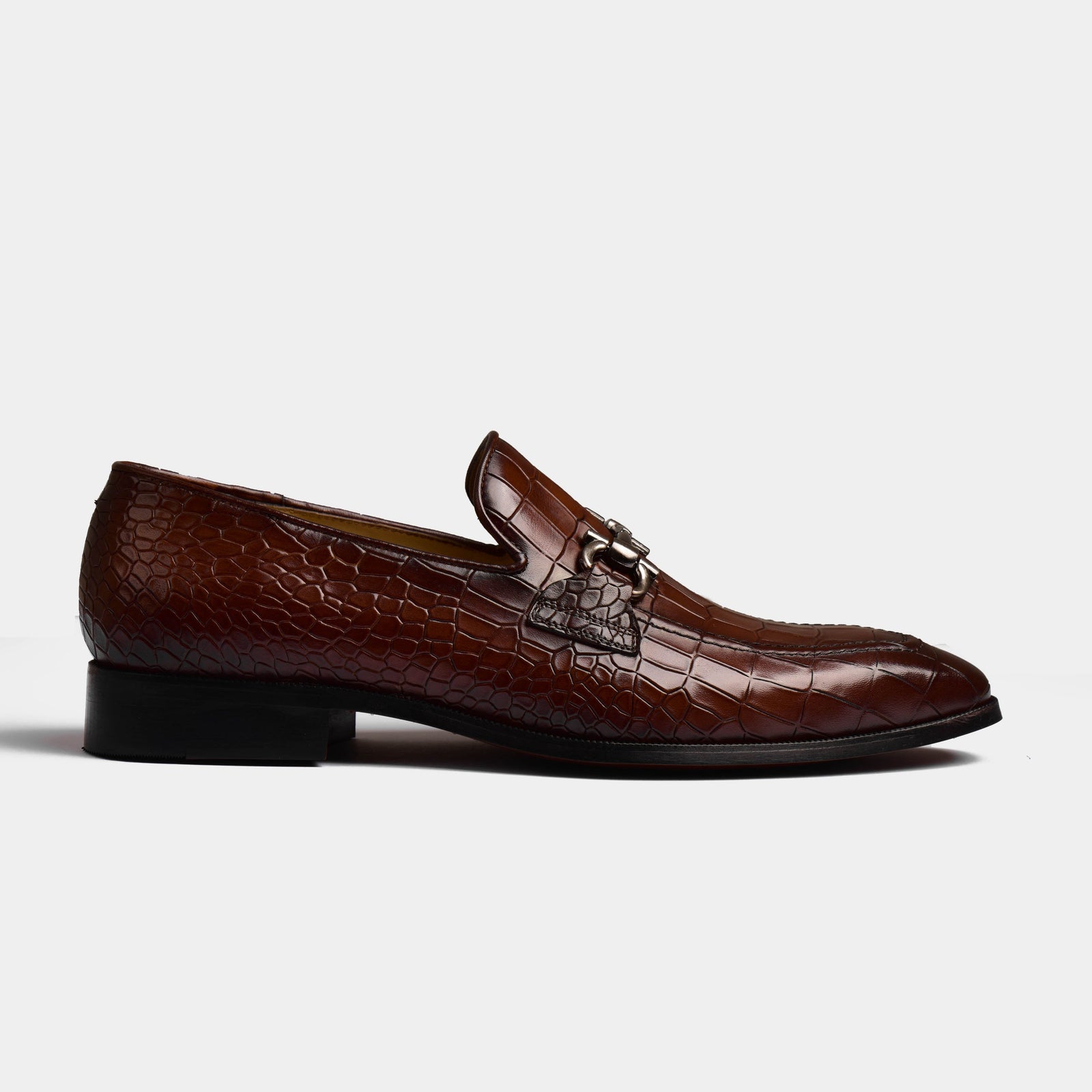 Side view of Liora Brown Leather Loafers with a crocodile skin texture and a silver buckle detail.