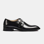 A sleek black leather Jake monk strap shoe with a single silver buckle, shot from the side on a white background.