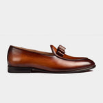 A side view of the Arno Loafer in brown patina leather, featuring a stylish bow-tie silhouette on the vamp.