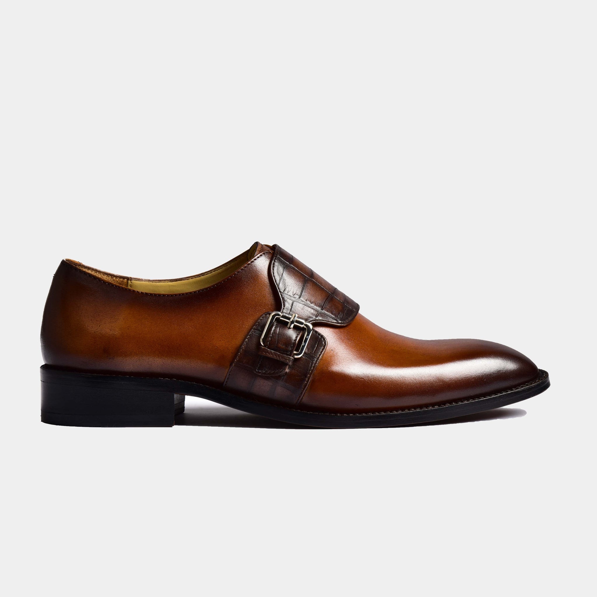 A side view of Jonathan Cognac Single Leather Monk Straps, showcasing the rich brown leather and alligator-embossed monk strap detail.