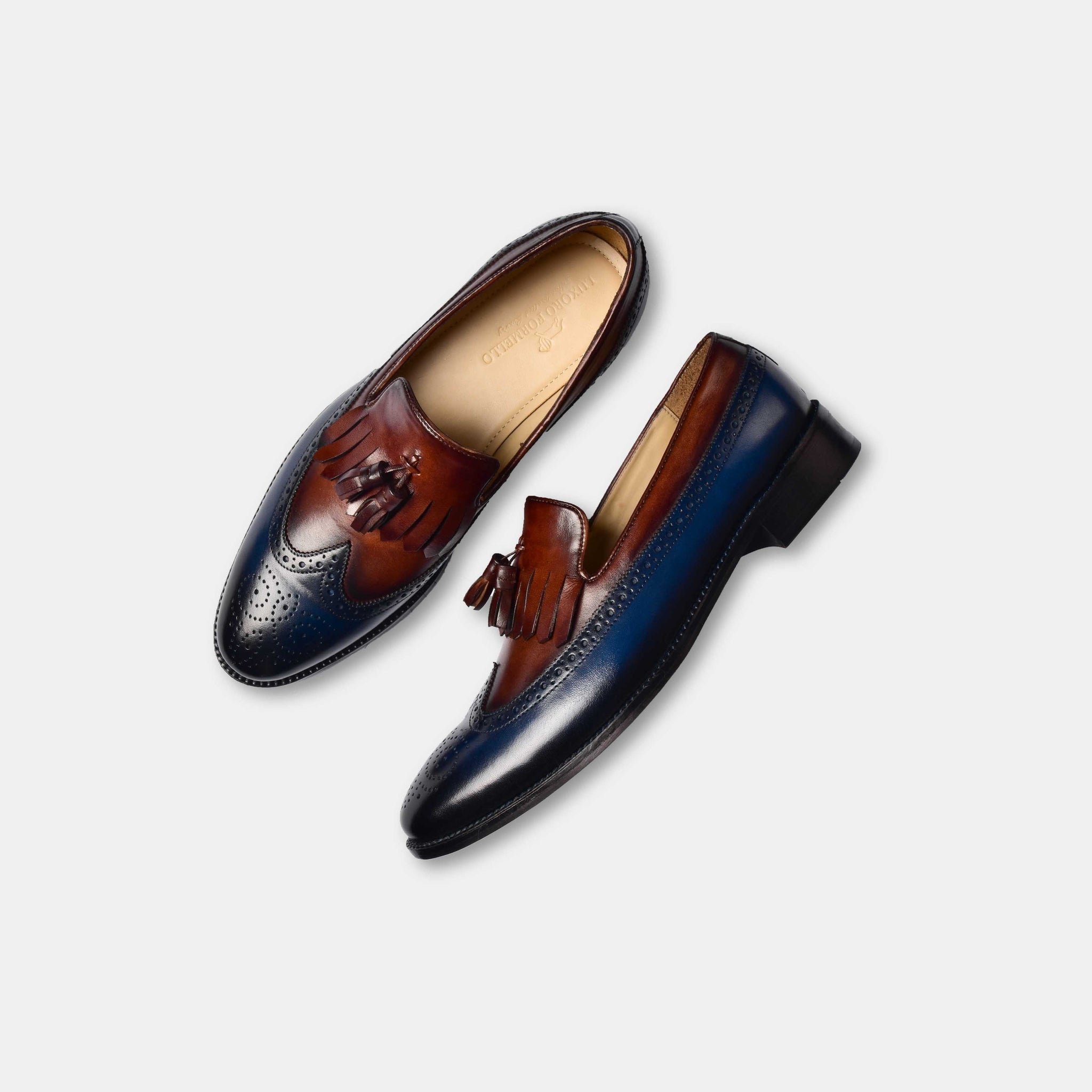 Stylish dual tone blue and brown leather loafers with tassel detail and brogue punching.